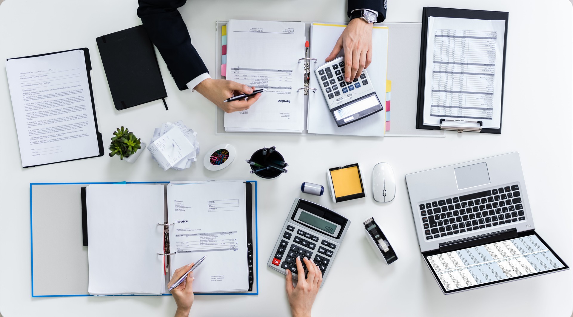 Two Businesspeople Calculating Bills In Office
